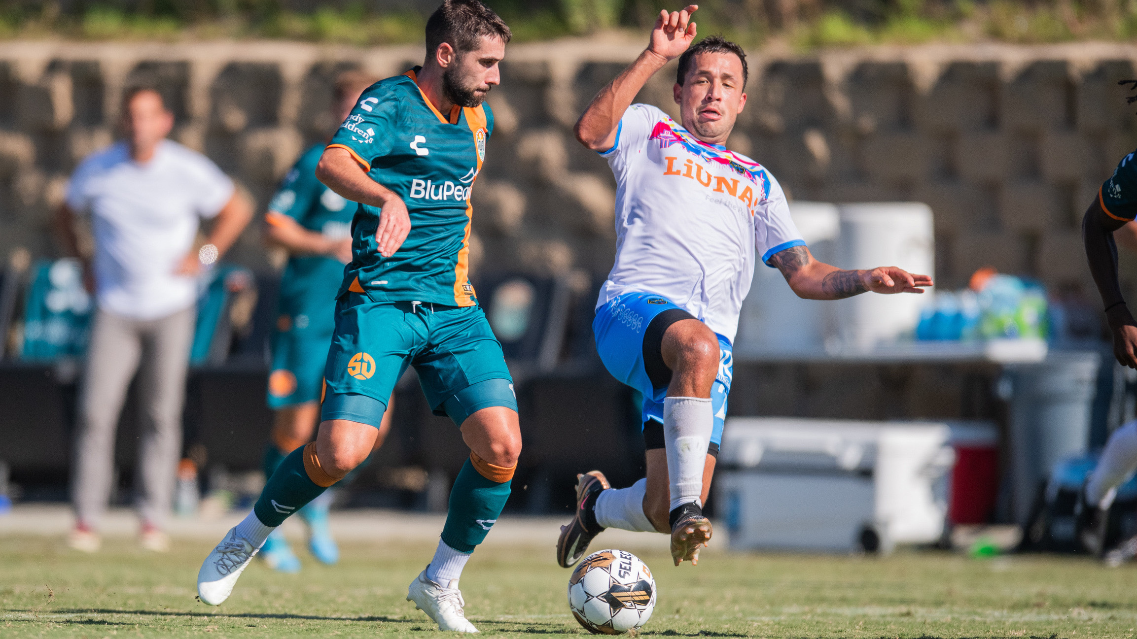 Charlie Adams chases down the ball with a Las Vegas Lights FC attacker behind him.