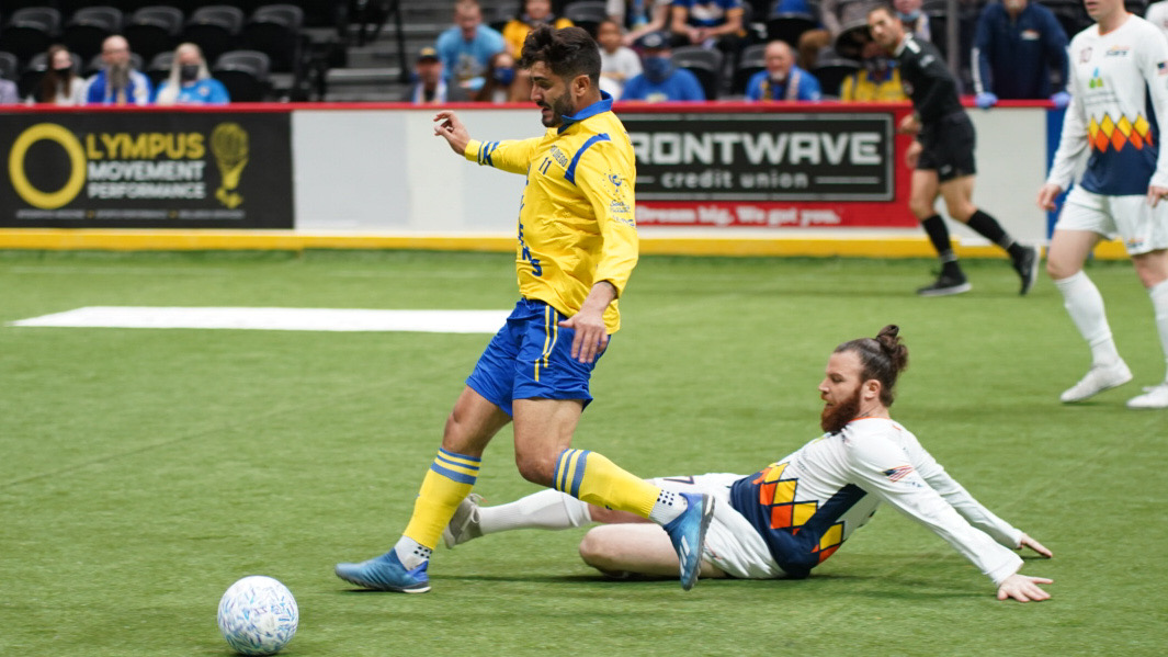 Leonardo De Oliveira passes the ball to a teammate while being run down by a Tacoma foe. 